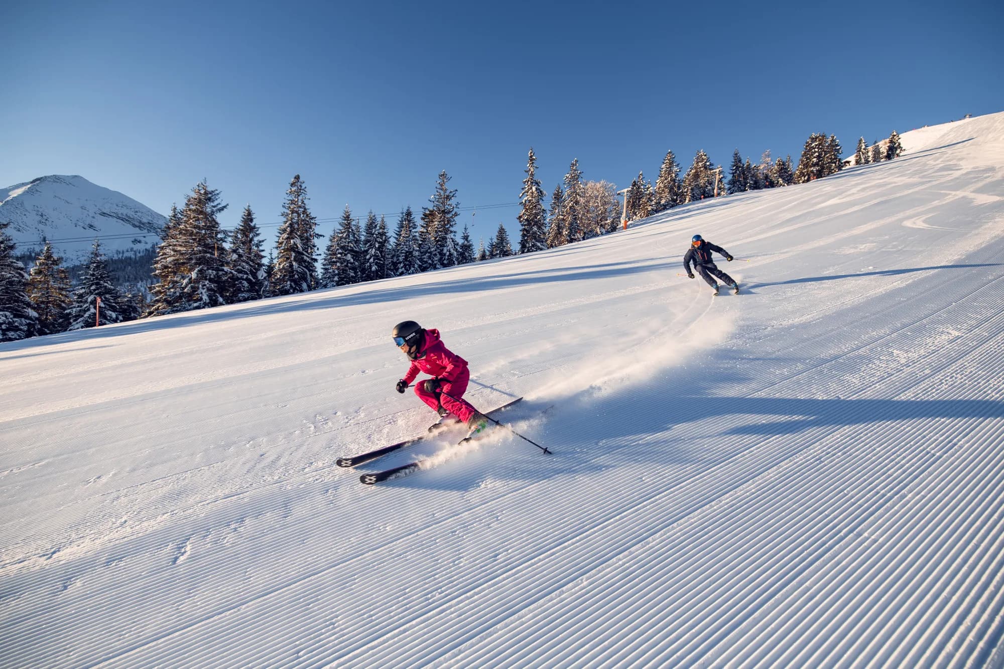 Zwei Skifahrer auf frisch präparierter Piste im Skigebiet Christlum