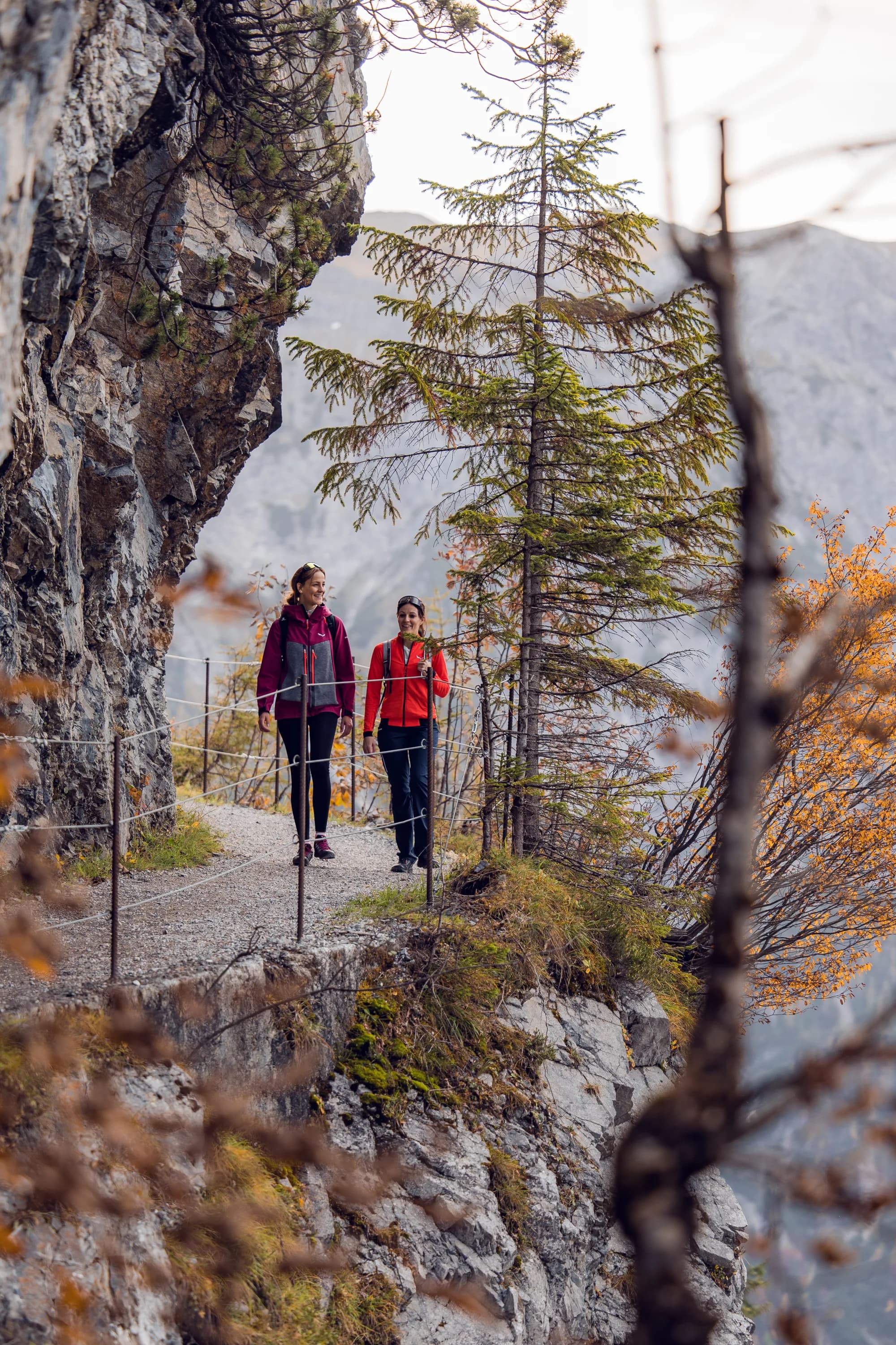 Zwei Wanderinnen gehen im Herbst den Tunnelweg Richtung Zwölferkopf entlang
