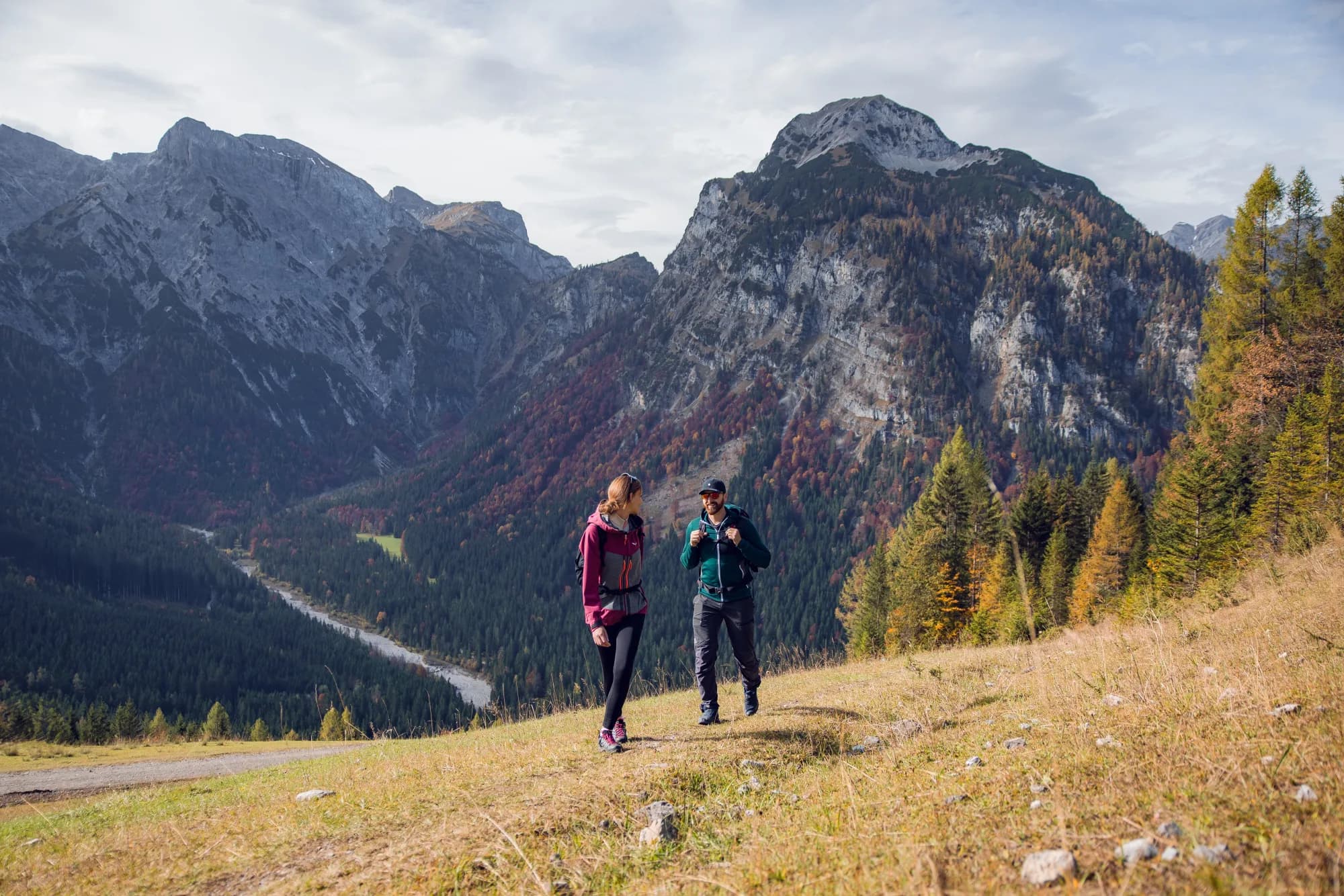 Zwei Freunde wandern im Herbst den Tunnelweg Richtung Zwölferkopf entlang