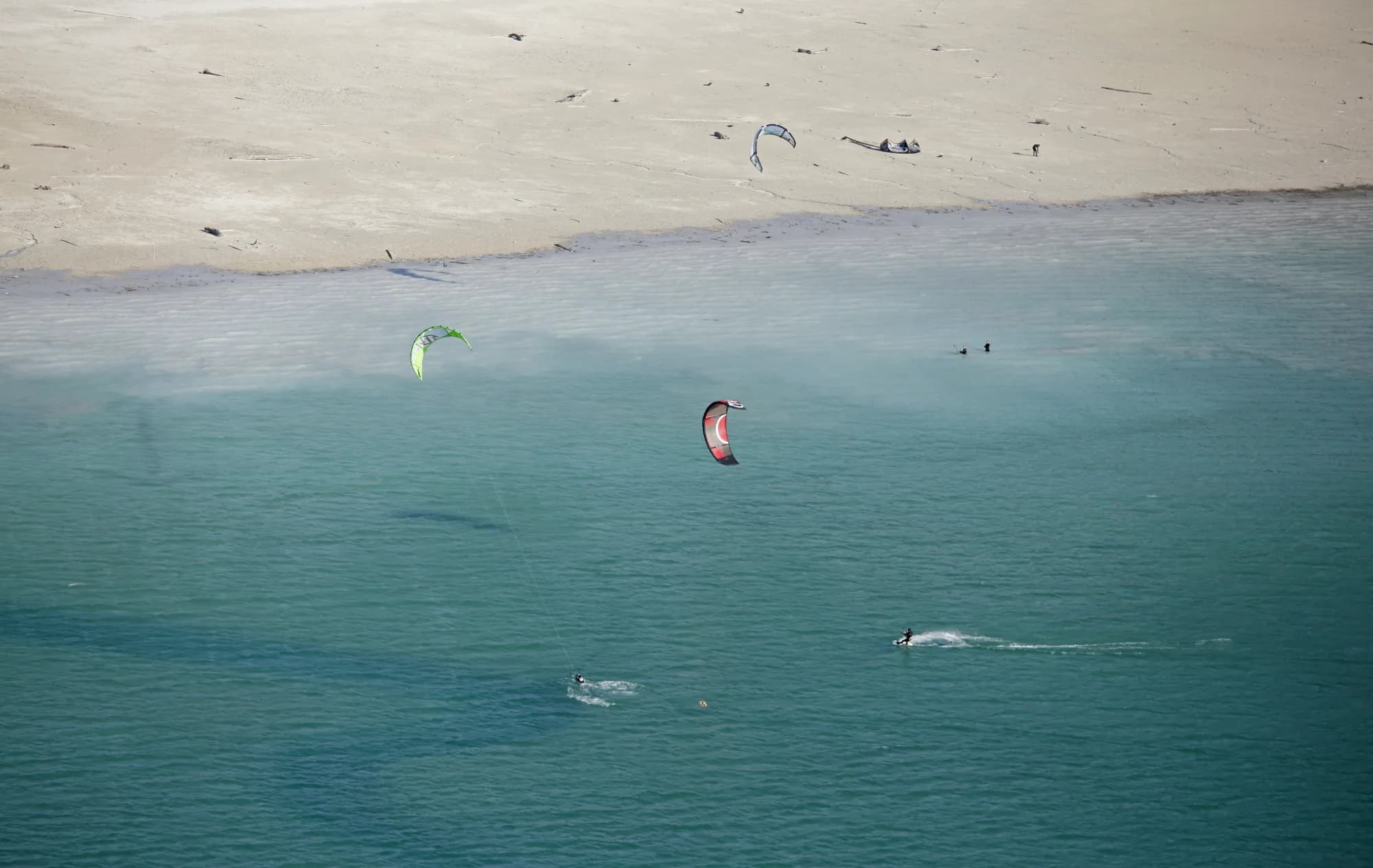 Kitesurfer und Kiter aus der Vogelperspektive im türkisblauen Wasser des Achensees