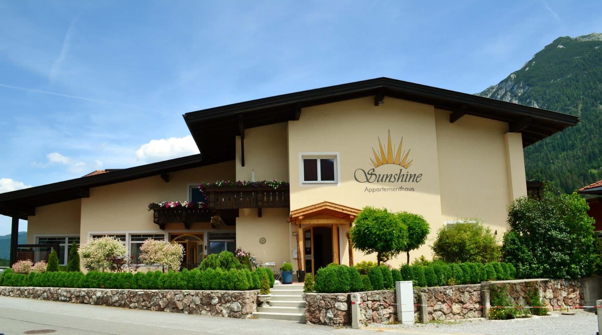 Das Appartementhaus Sunshine in der Sonne, dahinter die Berge