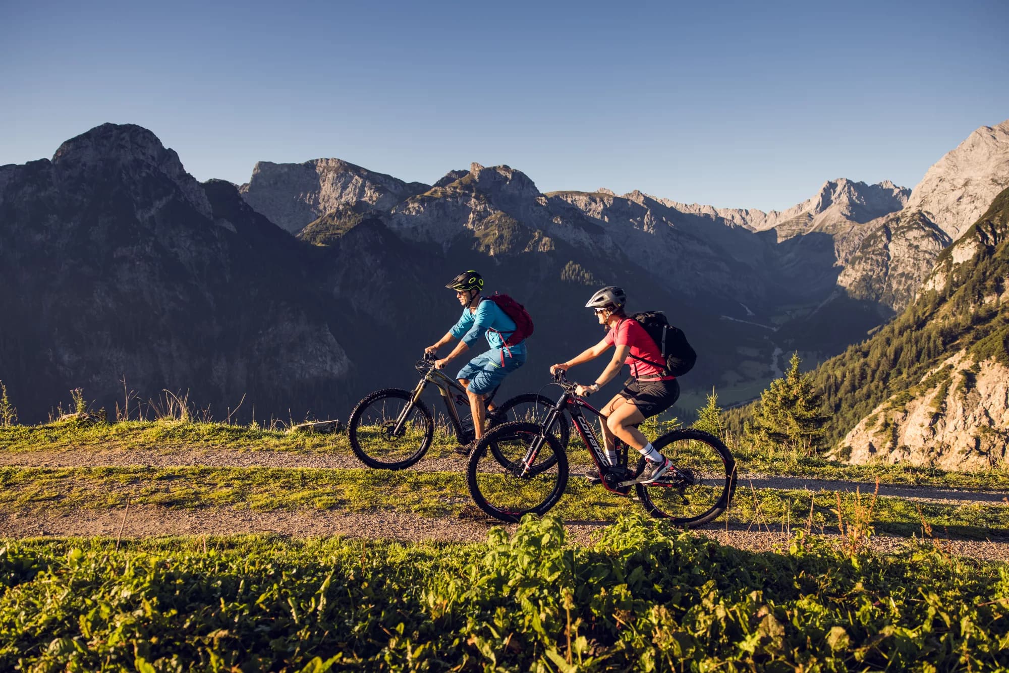 Zwei Mountainbiker auf einem Grat mit Panoramablick auf dem Weg zum Feilkopf