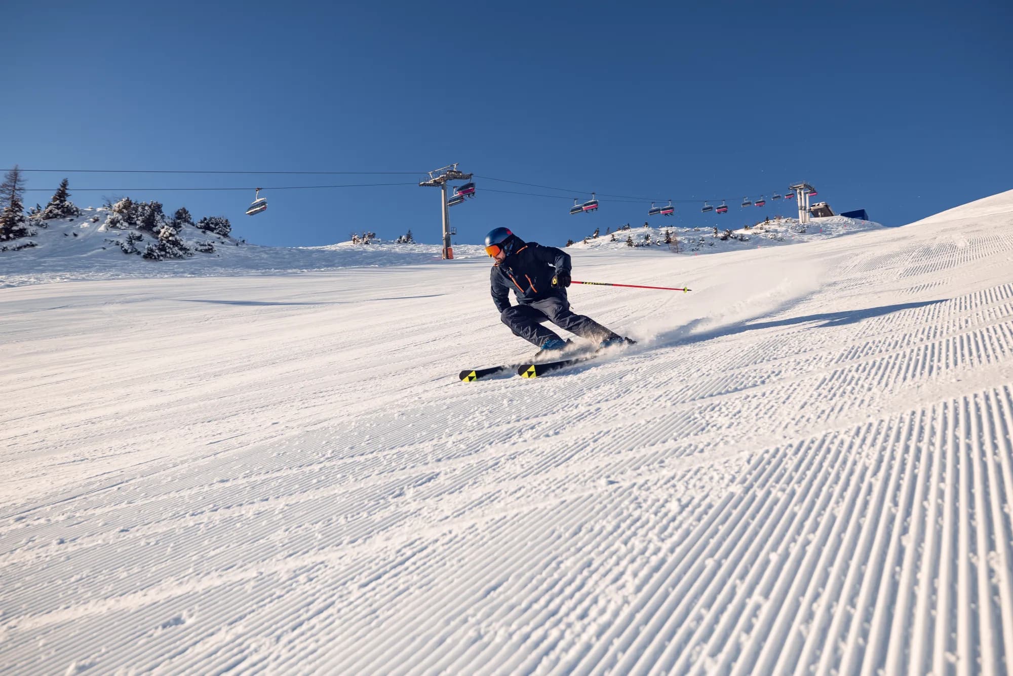 Skifahrer genießt bei strahlendem Wetter eine Abfahrt bei den Hochalmliften Christlum