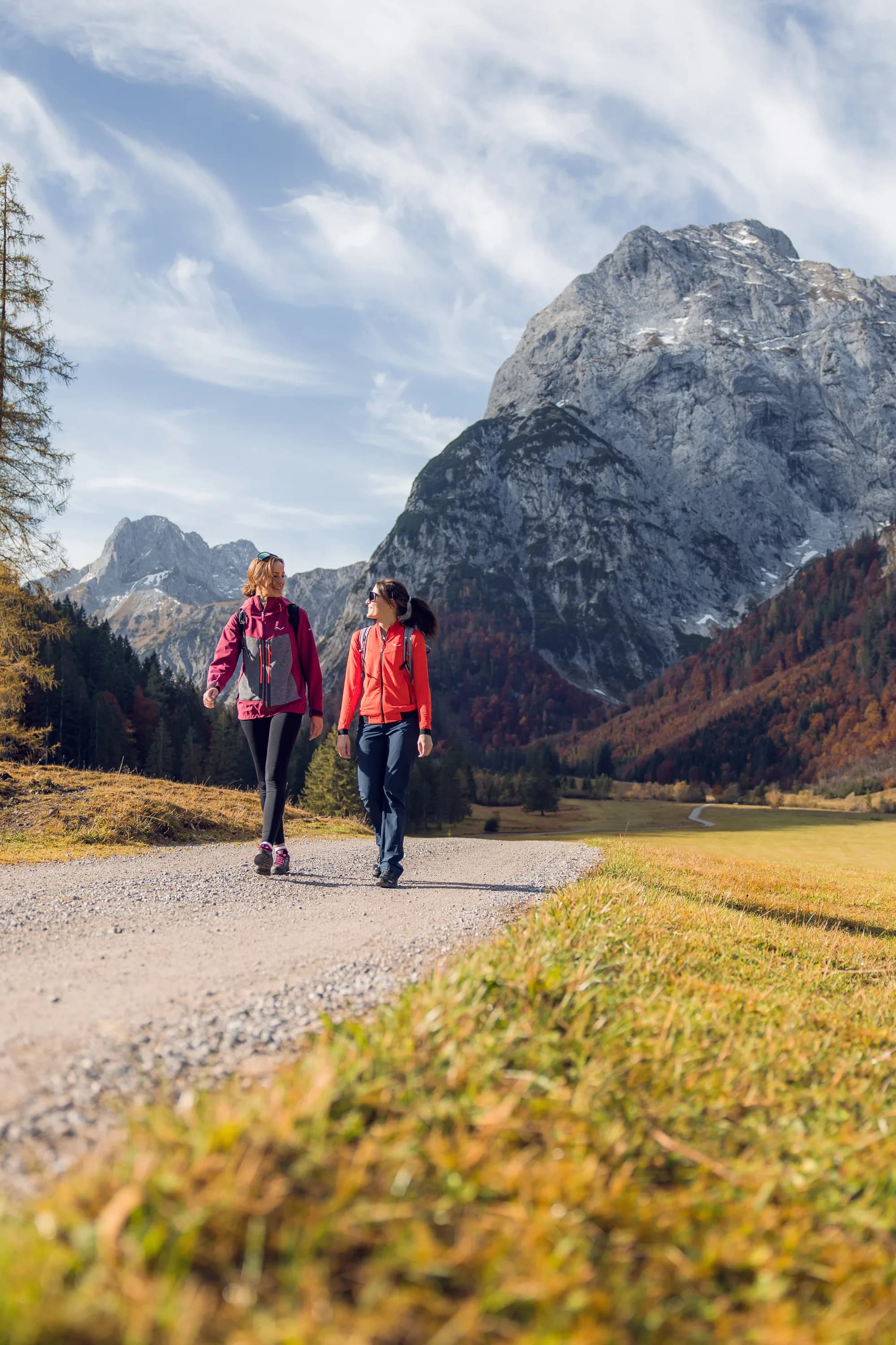 Zwei Wanderinnen im farbenfrohen herbstlichen Falzthurntal im Naturpark Karwendel