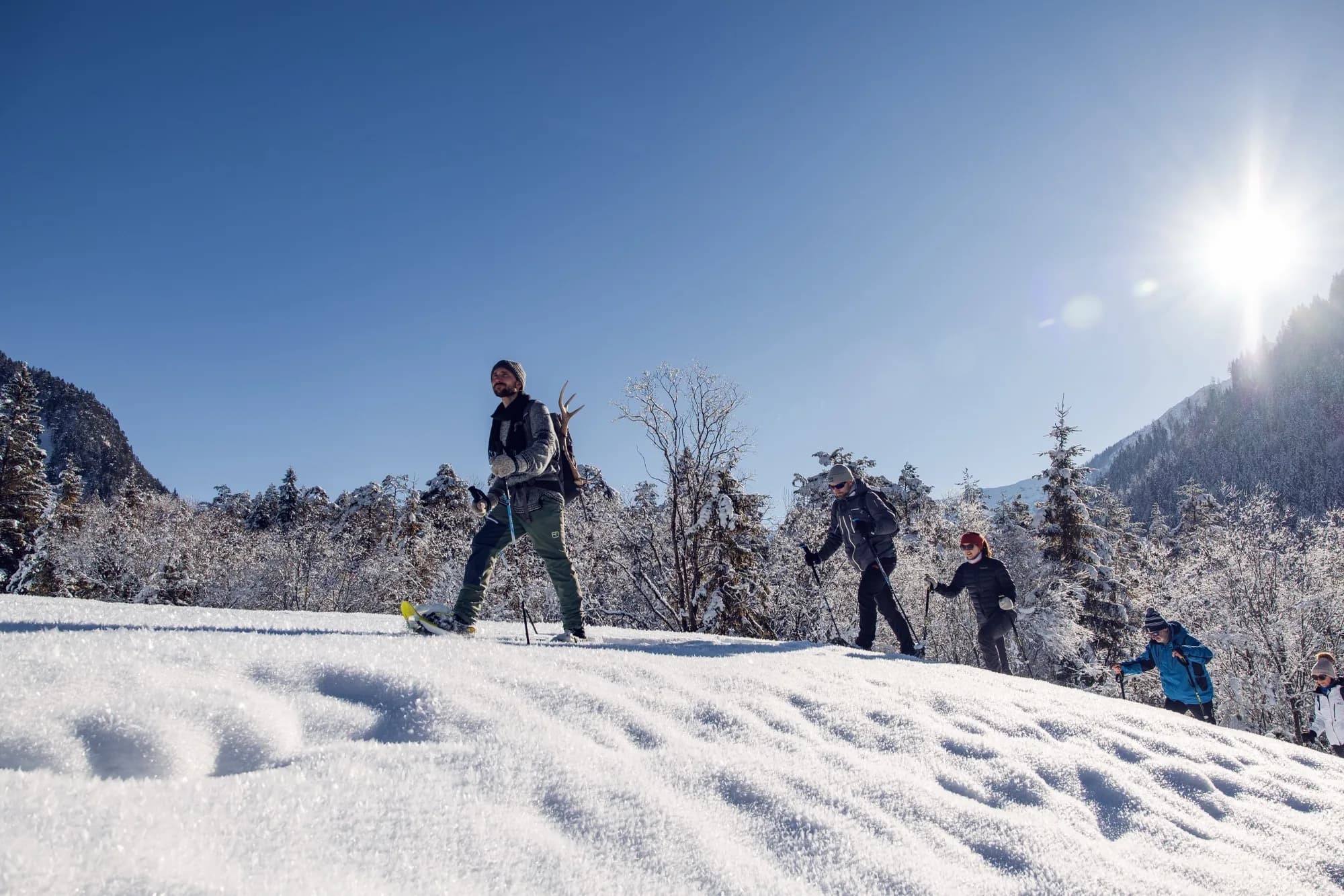 Schneeschuhgruppe zieht bei strahlender Wintersonne durch den Tiefschnee im Naturpark Karwendel